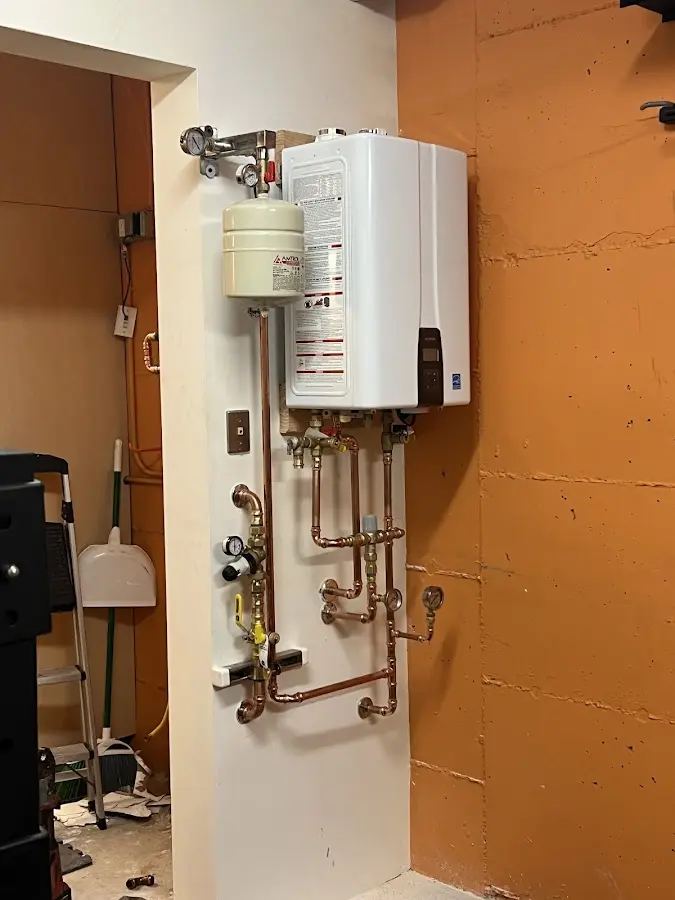 Plumbing technician inspecting water heater connections in Eldon